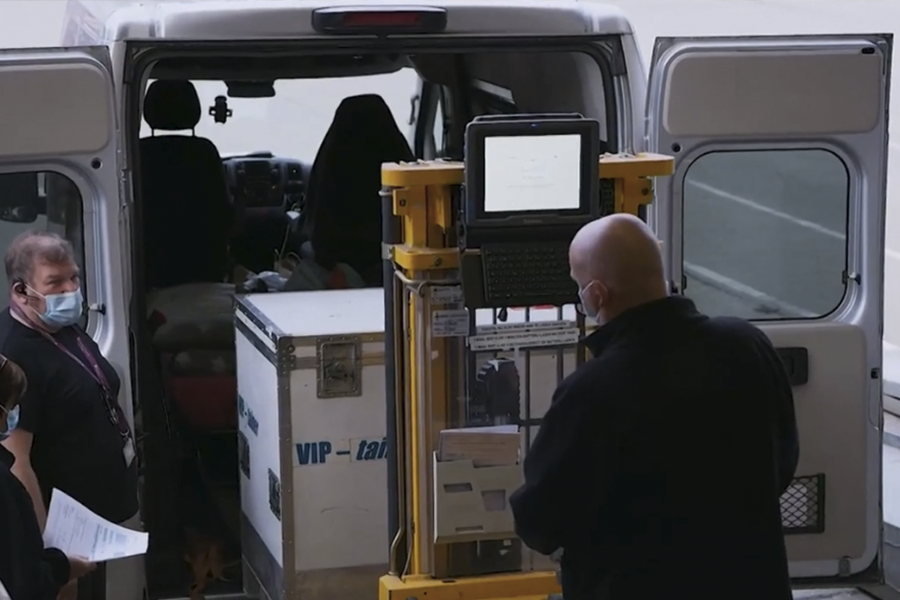 Dois homens estão descarregando a carga usando carrinho